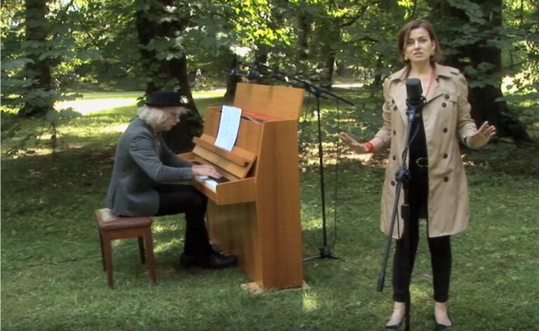 Zdjęcie wykonane w parku. Po prawej śpiewa Kaja Karaplios, Po lewej akompaniuje jej Joachim Mencel.