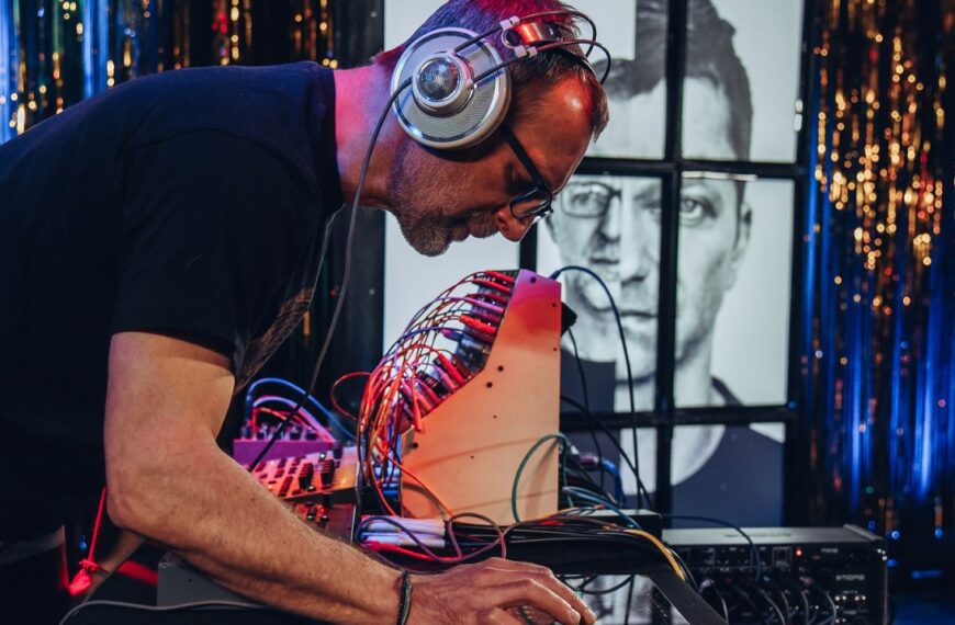 Mężczyzna z zespołu Automatik w słuchawkach pochylony nad sprzętem do grania