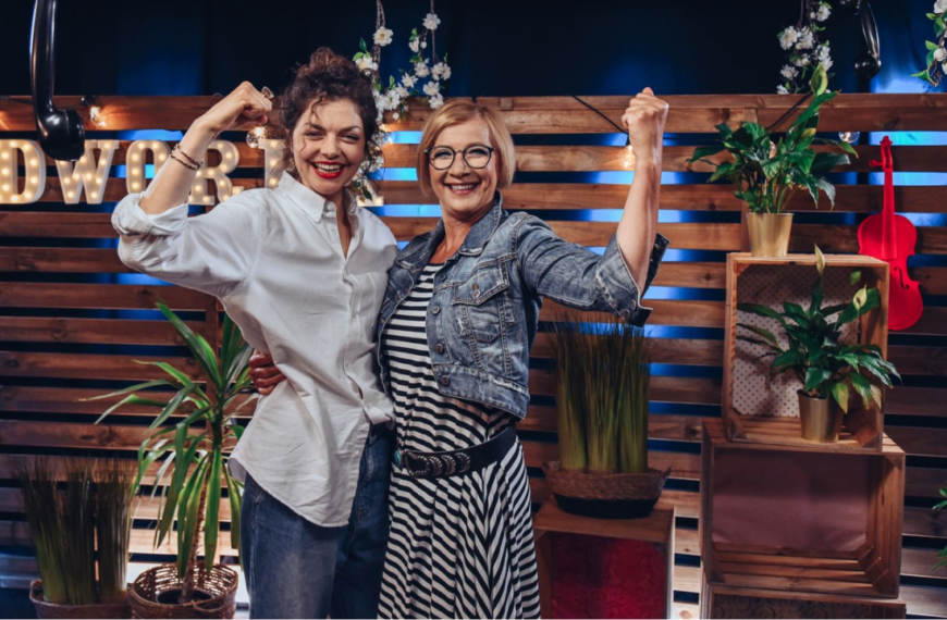 Dwie uśmiechnięte kobiety pokazują napięty biceps jako oznakę siły