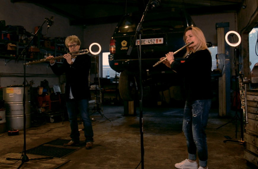 Kobieta i mężczyzna grają na fletach w warsztacie samochodowym