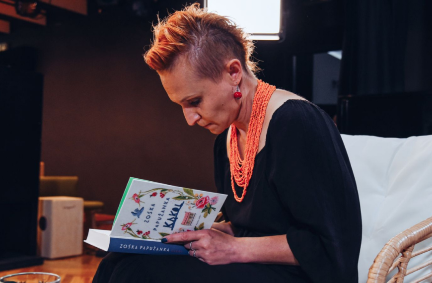 Zośka Papużanka pochylona nad książką podpisuje książkę