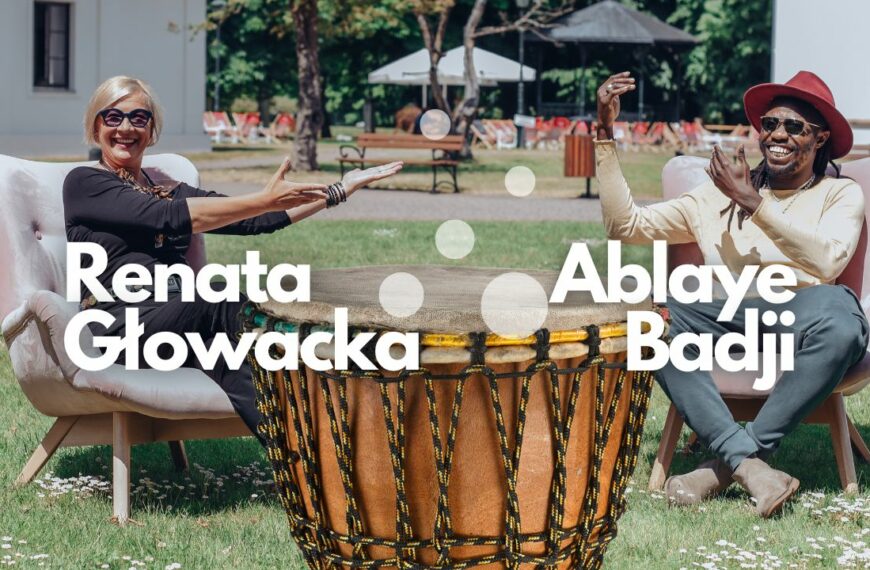 Renata Głowacka i Ablaye Badji siedzą na fotelach na trawie przed Dworkiem Białoprądnickim a między nimi stoki duży afrykanski bęben.