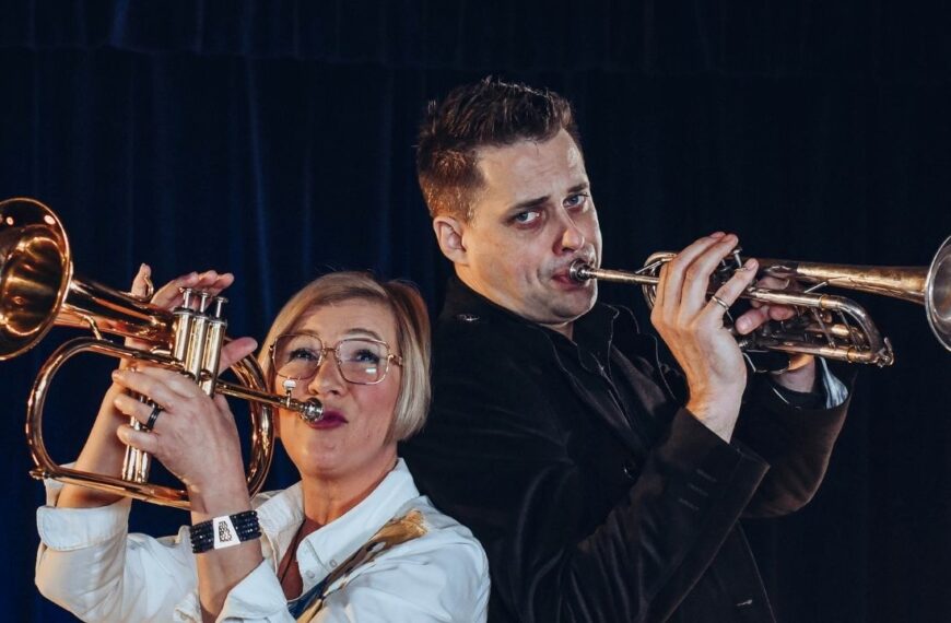 Przemek Sokół pozuje do zdjęcia z Renatą Głowacką grając na trąbkach w Dworek TV