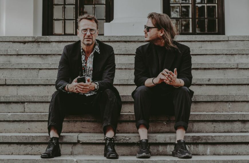 Mateusz i Marek Pospieszalski siedzą na schodach w Dworku Białoprądnickim.