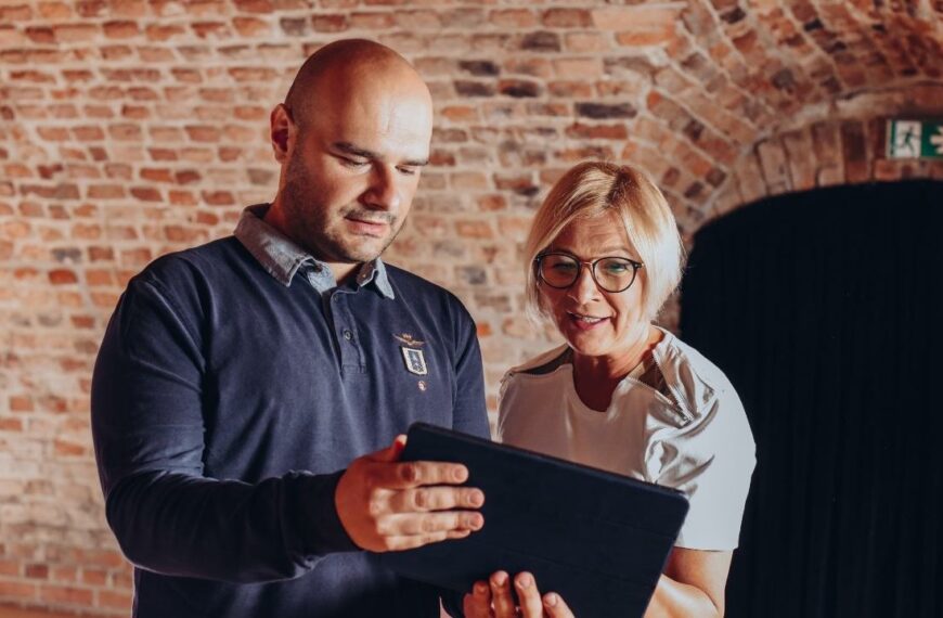 Renata Głowacka i Piotr Wilk patrzą na zdjecie w laptopie w studiu Dworek TV.